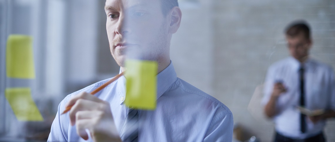 Businessman planning on a task board